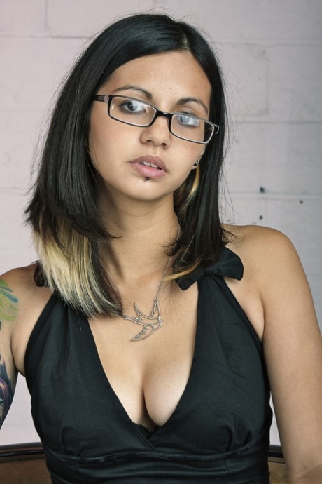 To pose in the nude, Holly D is seen wearing glasses and a dress with big tits and sheer panties.