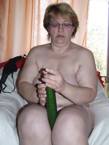 Sophie, who is mature and fatty, adds an English cucumber to her horny vagina.