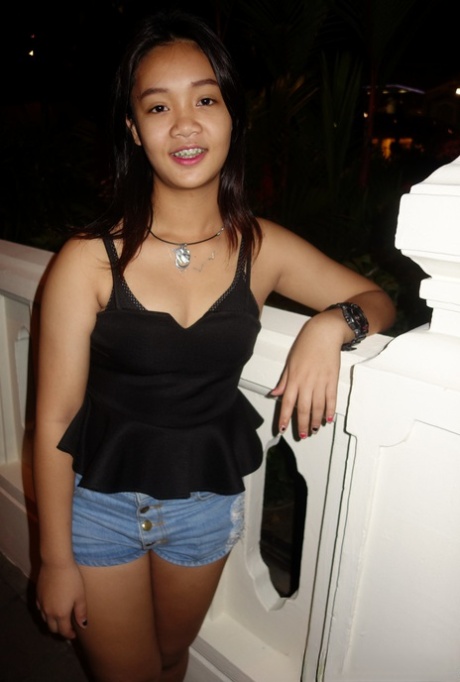 With braces and flip flops on, an adorable Thai girl lounged in her shorts and blouse.