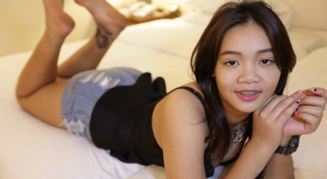 Cute Thai Girl In Braces And Flip Flops Lounges About In Her Shorts And Blouse