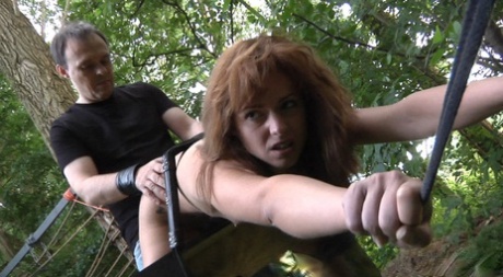 A brunette girl named Lora Summer is tied up and punished in the woods for having small tits.