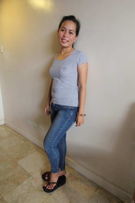 Mercy, a Filipina brunette, displays her prominent buttocks while wearing tight jeans.