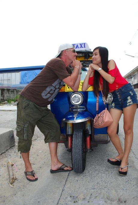 An attractive young Asian girl wearing flashy jean shorts is discovered on the sidewalk.