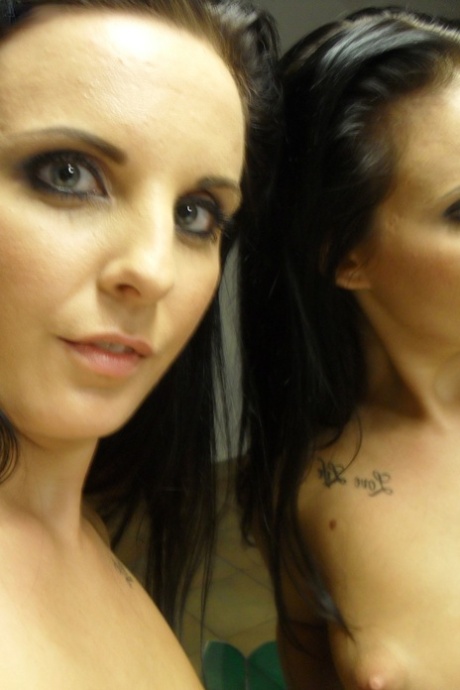 In front of a mirror, the attractive black-haired girl Tara Tattoo strips and performs some facial expressions.