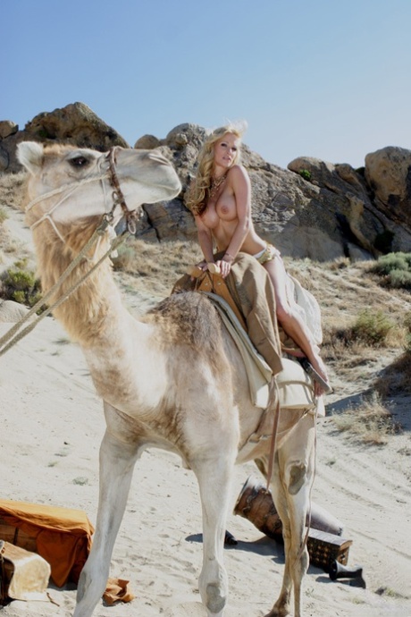 Kinky MILF Kaylani Lei flaunts her fake tits while riding a camel all nude