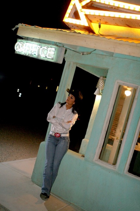 A brunette cowgirl named Carmen Hart displays her large booty and sassy.