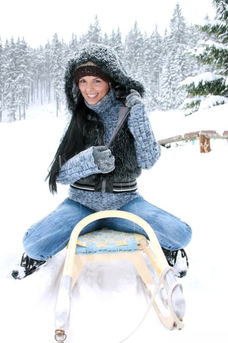 As she exercises with a toy in the snow, Ora, a brunette girl with big breasts, displays her strength.