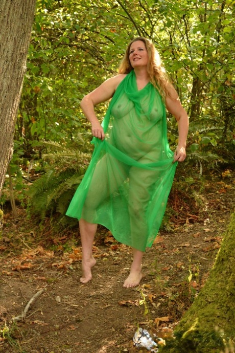 MILF, a redhead, was seen with a green tutu by Jade while rubbing her hairy twat outside.
