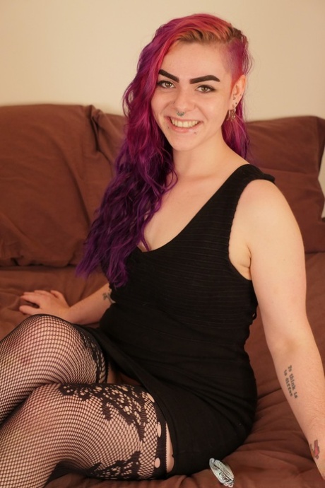 A female with multi-colored hair like Harley Queen enjoys masturbating in fishnets while naked.