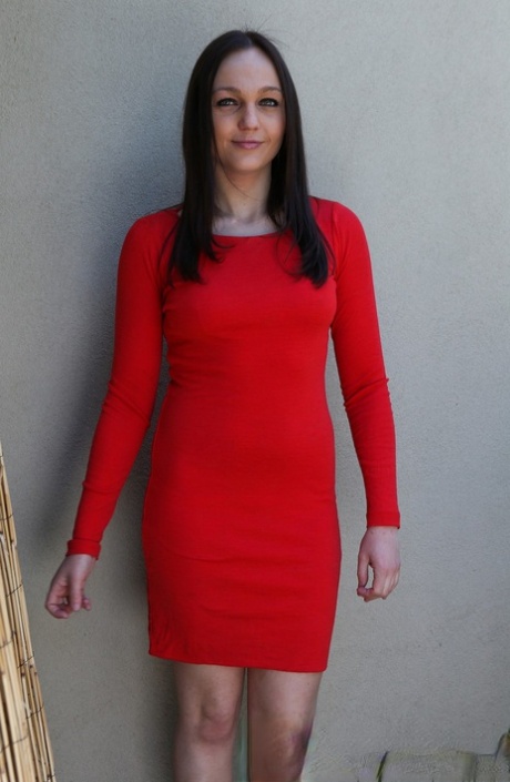 Anne Melbourne, the brunette in a red dress, displays her natural tits and shaved head.