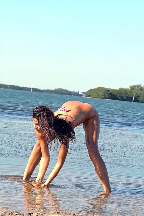 Teen in a sexy bikini Gia wetting her beautiful skinny body on the beach