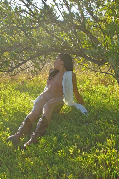 Amateur brunette Layla standing outside in nature, enjoying herself with her sexy wet body on display.