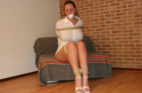 Big-booted blonde in heels, Deedee struggles and is flung with rope while gagged.