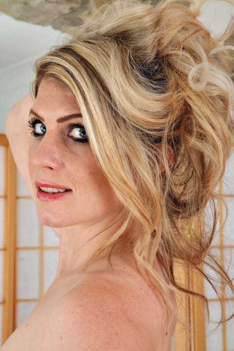 A blonde woman named Ashleigh McKenzie, who is still in her early twenties, extends her wet pussy.