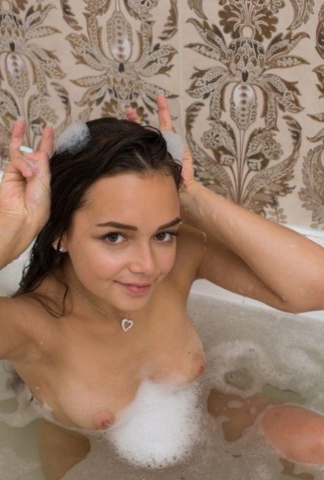 Teenager Slava displays her radiant physique while taking a bubble bath.