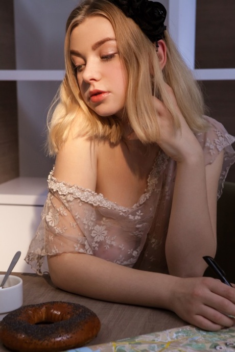 The beautiful blonde, Daniel Sea, exhibits her stunning tits and is nude sitting on a chair.