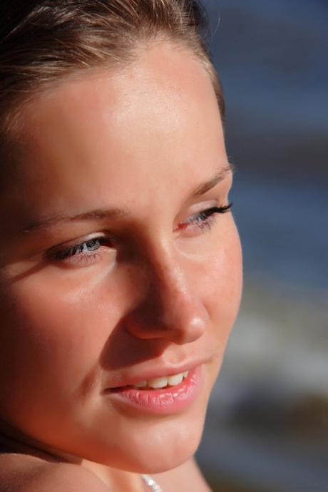 A naked Irina O flaunts her bald head while enjoying the beach.