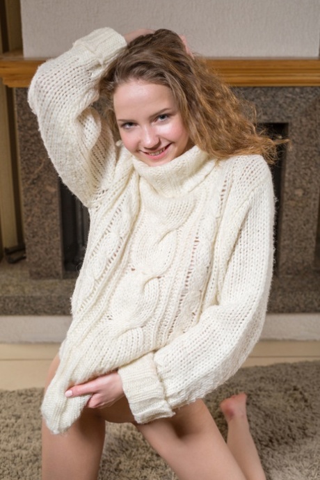 Faina Bona, a delightfully cute girl from Belarus, was photographed naked on the carpet near the fireplace.