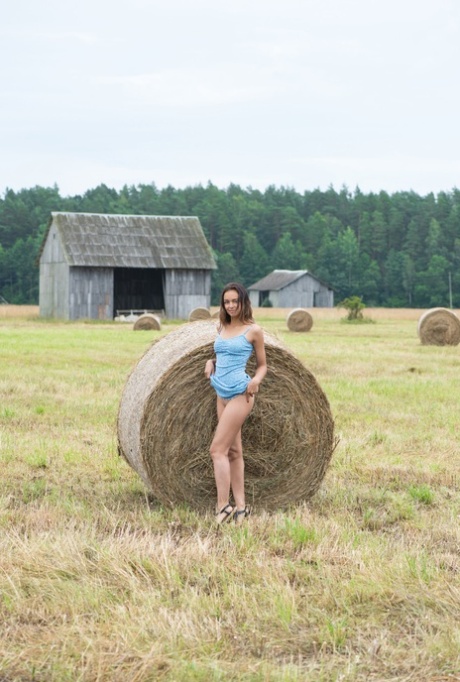 A Belarusian model named Slava is depicted stripping and posing as a naked Buck in a hay field.
