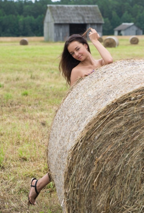 The Belarusian beauty, Slava, was captured on camera in a hay field, stripping and holding up her hair as a naked Buck.