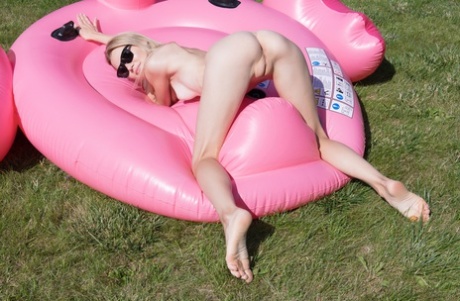 Glamorous teen babe Celestine posing naked in a flamingo floaty