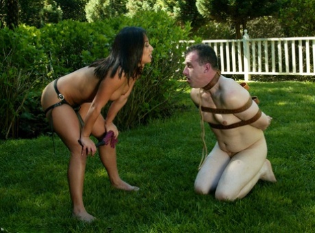 Outdoors, Domina Jasmine Byrne administers anal punishment to her stranded sub.
