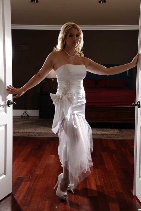 Sexy blonde bride sheds her wedding gown to pose topless in stockings & garter