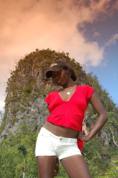 Outdoors Ebony Maria L removes her shorts and red shirt before choking on with the ass firmly in place.