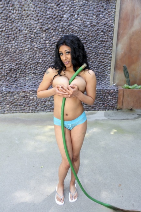The large breasts of London, accentuated by her black haired ebony locks, are showcased while she flaunts her cockles.
