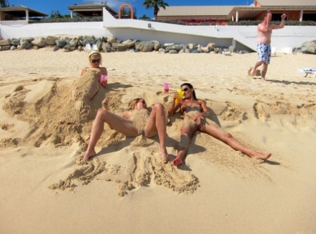 Exoticly nude: Blonde lesbian Bibi Noel and her lustrous girlfriends run around the beach naked.