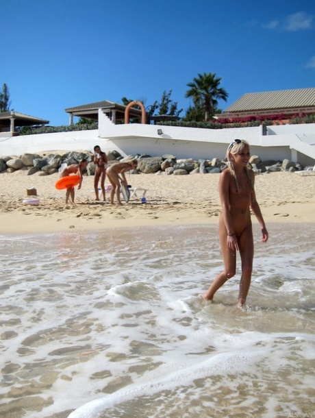 Despite being naked, blonde lesbian Bibi Noel and her flirtatious female companions roam the beach without clothes.