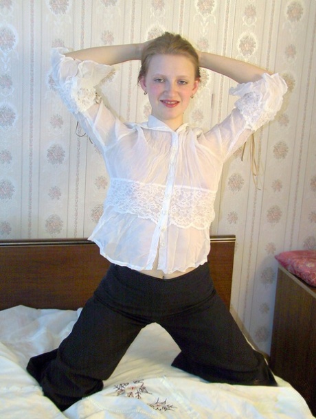 Small tits: Teenager Lusya shows her body and poses on a bed.