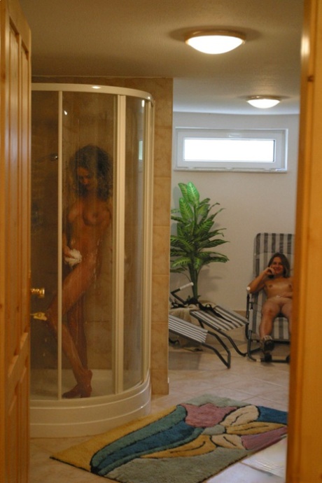 In the shower, Sonya displays her large breasts while wearing a curly hairstyle.