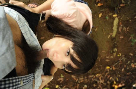 Insect body blowing from above: Asian model Riko Tanabe (right) performing a POV while on her knees outside.