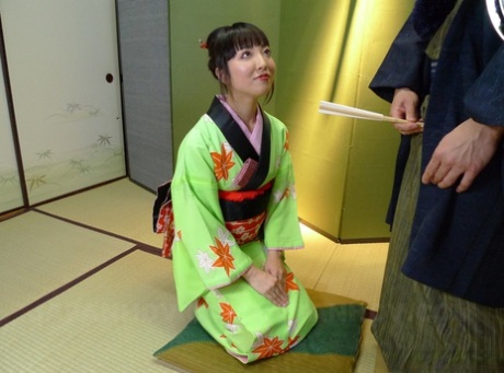 A hairy cock is given POV by a Japanese woman wearing a green kimono.