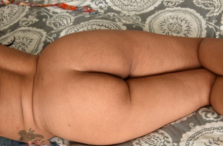 MiLF Cierra, a gorgeous ebony breed, displays her substantial buttocks in the buff on her bed.