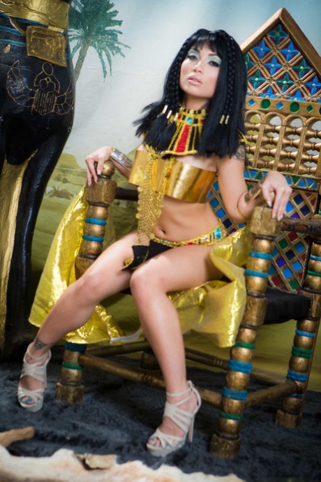 A woman of Chinese descent, Rina Ellis from Petite Asian showcases her breasts and buttocks in the style of Cleopatra.