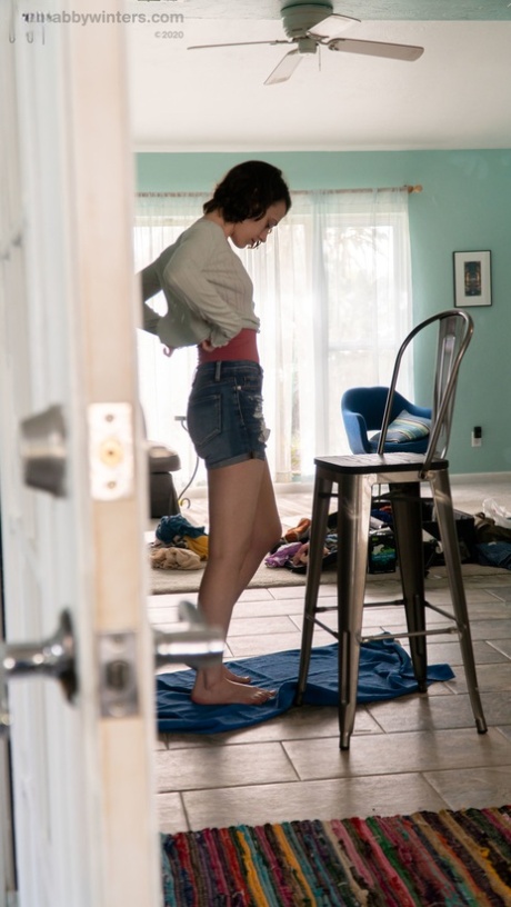 The amateur girl with black hair, Taylor M, dresses in her denim shorts and tight shirt.
