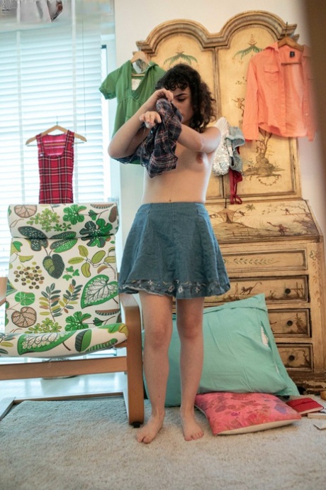 Minimalist Kitty D is seen in a nude pose before wearing her darling skirt with sequins on her back.