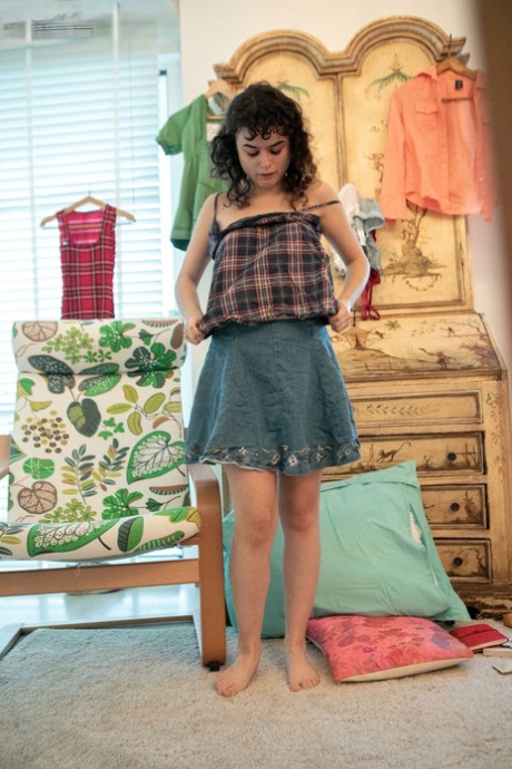 Kitty D, a petite and attractive individual, takes a naked walk before wearing a high-cut skirt.