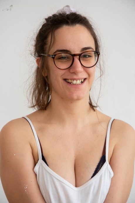 A glasses-wearing Lucia M shows off her boobs and hairy vagina before proudly fingering it.