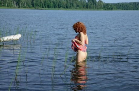 A naked Sunny strips for a solo water play session in the lake with its sexy face and big ass.