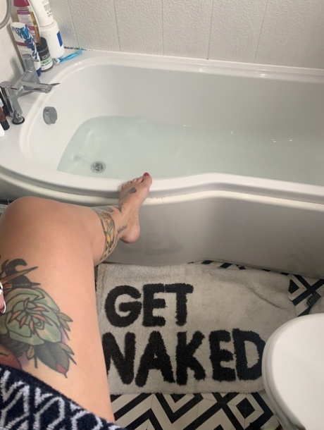 While bathing in her tattooed body, Cherrie Pie displays her oversized chest muscles.