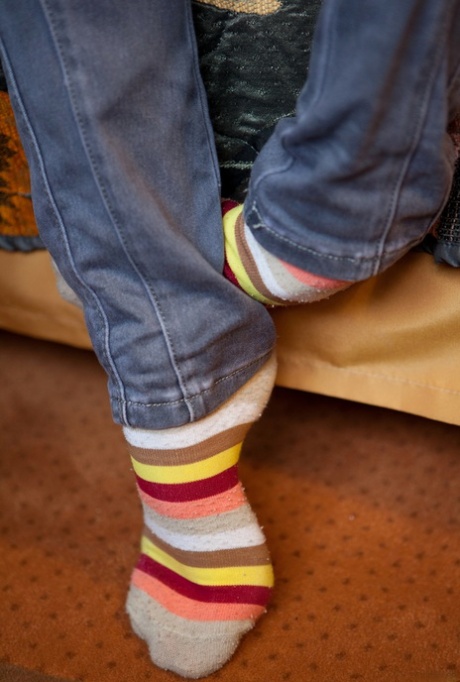 On the sofa, Queva (a tiny girl wearing black stockings) plops her innocent kissing on the floor.