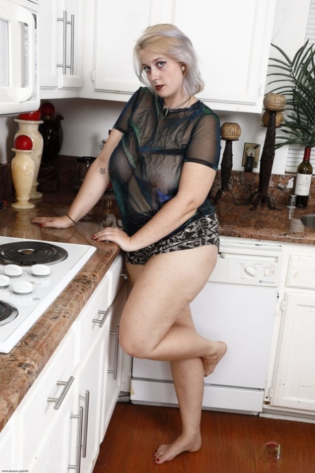 Working blonde Nyx Night displays her hairy vagina in the kitchen.