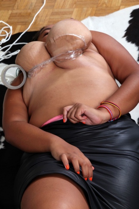 Chubby ebony's mother, MILF Roza, releases her large breasts and secures them with tape.