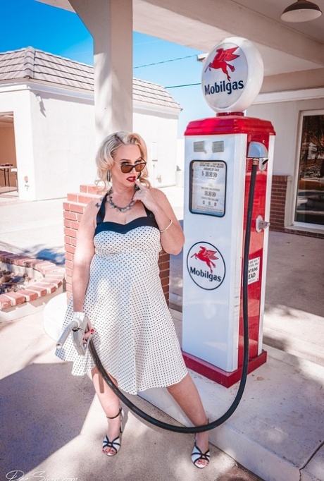 Exposed butt: Retro pinup MILF Dee Siren poses at a gas station with her fat buttocks on display for all to see.