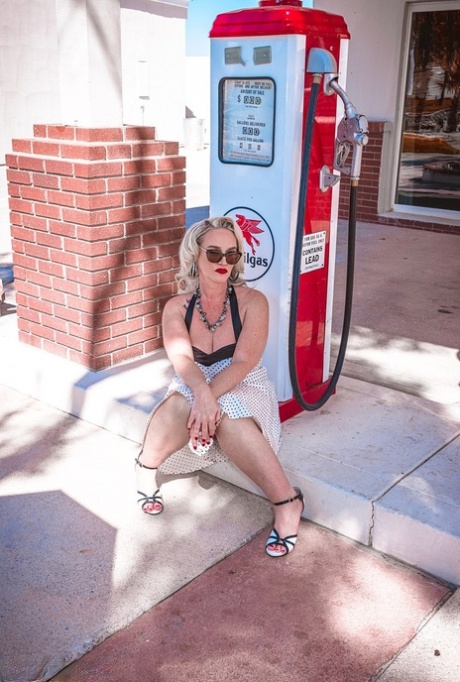Exposed buttocks: Dee Siren, a retro pinup winner from MILF, poses at a gas station in the shape of her big buttocks.