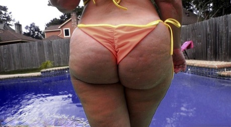 In the pool, Dee Siren is seen in her mature PAWG and posing in her trademark orange bikini.