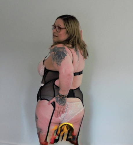 BBW Kandi Karter, with her tattooed on seductively, wearing baggy bottoms and high heels.